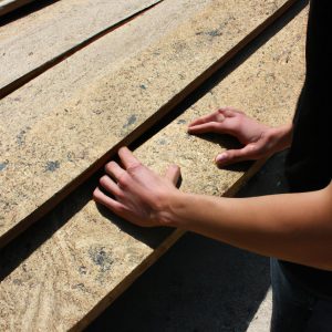 Person inspecting wooden boards